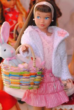 a doll is holding a basket with stuffed animals in it and wearing a pink dress