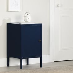 a blue cabinet sitting in front of a white door with a clock on top of it