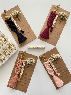 four different tassels are shown on top of brown cards with words and beads