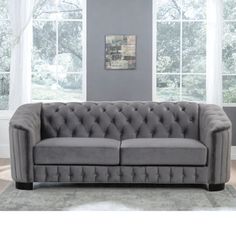 a gray couch sitting in front of two windows