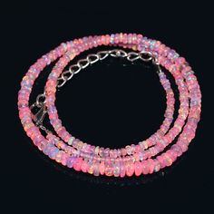 three strand bracelet with pink beads and silver clasps on black background - product images