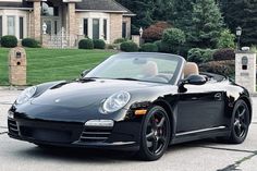 a black sports car parked in front of a house