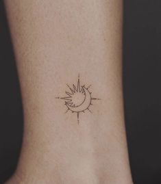 a small sun and moon tattoo on the back of a woman's neck,