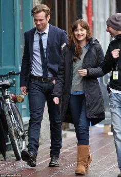 two men and a woman walking down the street