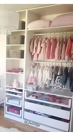 a baby's closet with lots of clothes hanging on the wall and drawers below