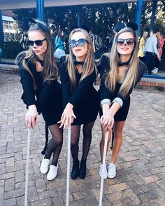 three girls dressed up in costumes posing for the camera with crutches and canes