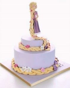 a purple cake with a girl standing on top