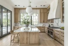 a large kitchen with wooden cabinets and marble counter tops