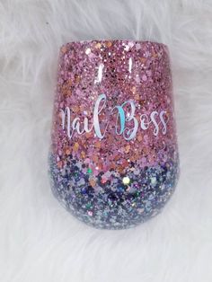 a pink and blue glitter wine glass with the word nail boss on it's side