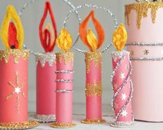 some pink candles are decorated with gold sparkles