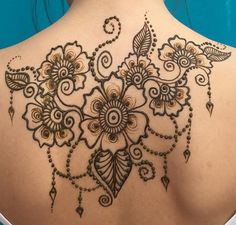 a woman's back with henna tattoos on it