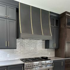 a stove top oven sitting inside of a kitchen next to gray cupboards and cabinets