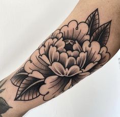 a black and white flower tattoo on the arm