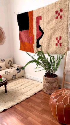 a living room filled with furniture and a rug on the wall next to a couch