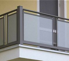 a close up of a balcony with a clock on the wall and a building in the background