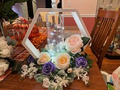 a wooden table topped with a glass vase filled with flowers