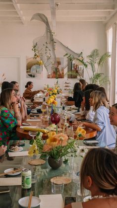 a group of people sitting around a table with food and drinks in front of them