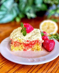 a piece of cake on a plate with strawberries and lemons next to it