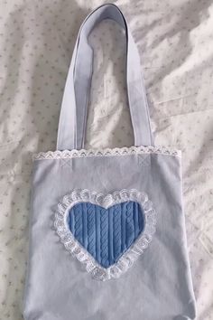 a blue heart shaped bag sitting on top of a bed