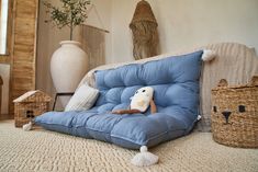 a child's stuffed animal is sitting on a blue futon in the living room