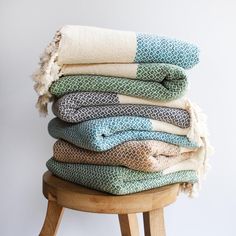 a stack of towels sitting on top of a wooden stool