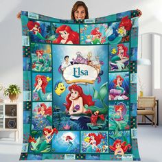 the little mermaid blanket is being held up