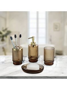 three bathroom accessories on a marble counter top