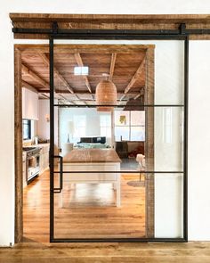 an open kitchen and living room are seen through the sliding glass doors that lead into the dining area