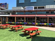 there are picnic tables in front of the restaurant and on the green grass area outside