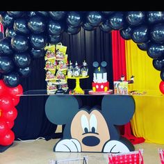 a mickey mouse themed birthday party with balloons