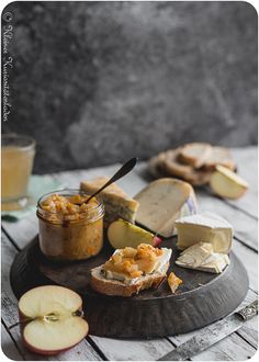 an apple and cheese sandwich on a plate with two glasses of juice next to it