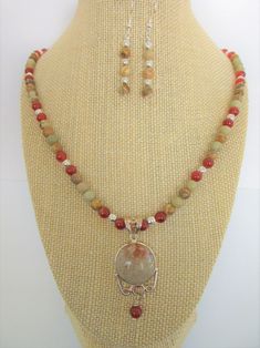 "3 Piece Jewelry Set. Pendant-Rare Fossil Coral and .925 Silver Pendant,2.25 drop including heart motif w/carnelian bead Necklace - 6 mm Rainbow Jasper beads,Carnelian, Silver beads.21 inches w/3 inch extender .925 chain and hook Earrings - 6 mm Rainbow Jasper Agate beads, 2\" drop  Earrings on Sterling Ear wires. The inch diameter Fossil Coral, is made from the preserved skeletons of marine coral  (which is not to be confused with endangered coral).  Flower-like patterns are left in the fossili Natural Stone Jasper Dangle Jewelry, Dangle Jasper Jewelry With Natural Stones, Natural Jasper Stone Dangle Jewelry, Multicolor Beaded Carnelian Jewelry, Multicolor Carnelian Round Bead Jewelry, Multicolor Carnelian Bead Jewelry, Multicolor Round Carnelian Bead Jewelry, Multicolor Jasper Jewelry For Gift, Round Jasper Healing Jewelry