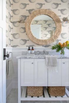 a bathroom with a sink, mirror and two wicker baskets on the counter top