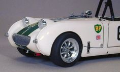 an old model white sports car with green stripes