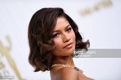 a close up of a person wearing a dress and necklace on the red carpet at an event