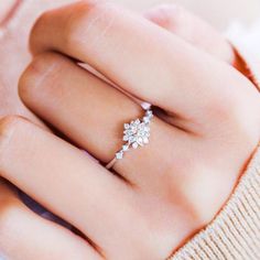 a woman's hand with a diamond ring on it