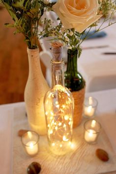 two vases filled with flowers and lit candles