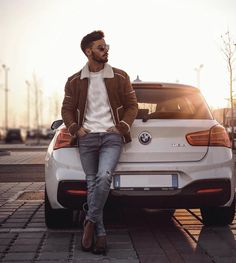 a man sitting on the hood of a white car