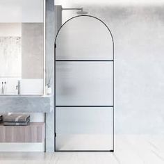 a white bathroom with an arched glass door