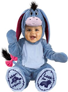 a baby in a blue winnie the pooh costume with ears and tail sitting down