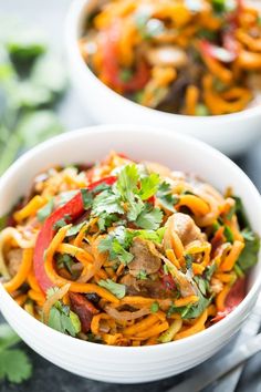 two white bowls filled with noodles and vegetables