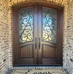 the entrance to an elegant home with two double doors and a welcome mat on the front door