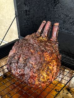 a large piece of meat sitting on top of a metal rack next to a grill