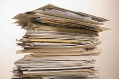 a stack of papers sitting on top of a wooden table