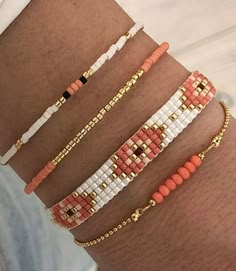 four different bracelets on someone's arm, one with an orange and white beaded