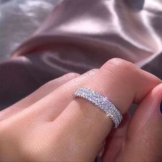 a woman's hand with a diamond ring on her finger and blue nail polish