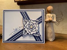 an angel figurine next to a card on a table