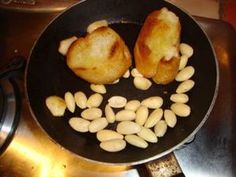 some food is cooking in a frying pan on the stove top and ready to be cooked