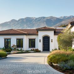 a white house with mountains in the background