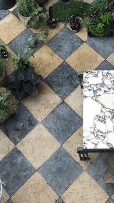 an aerial view of a tiled patio with potted plants on the side and a bench in the middle